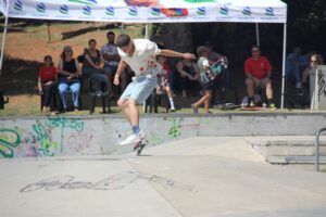 A young man performs a trick at a skate park.