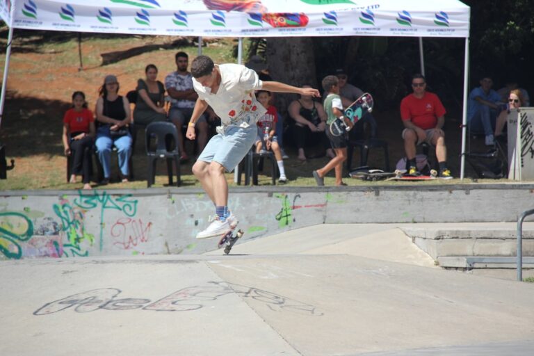 A young man performs a trick at a skate park.