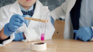 Children in lab coats conduct a science experiment.