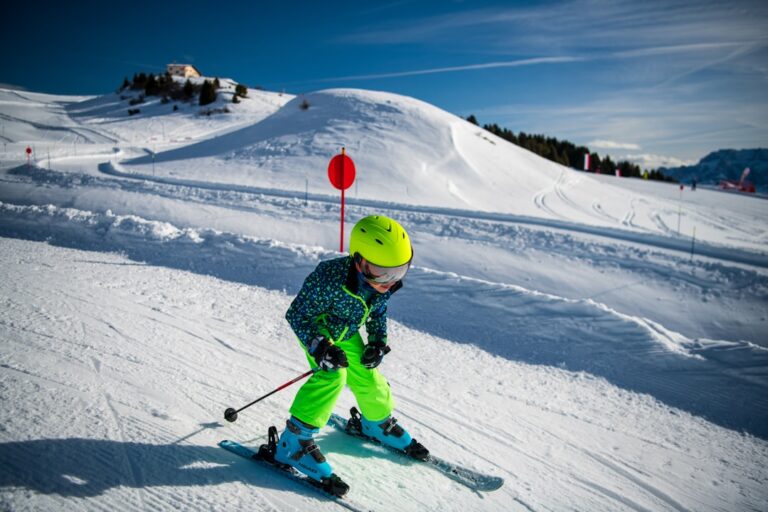 Young child skiing down a snowy mountain slope