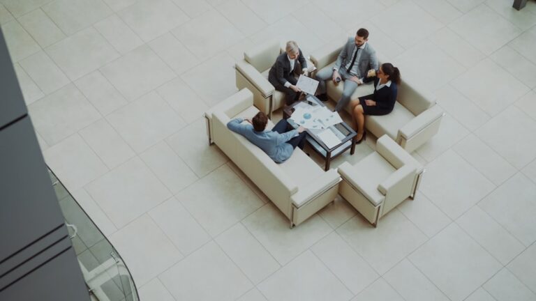Business people meeting on sofas in a modern lobby.