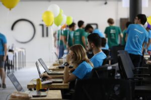 a group of people working on laptops in a room