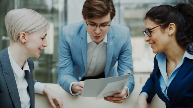 Three professionals discussing a document together