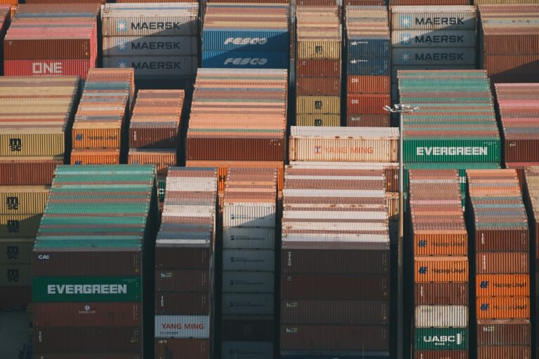 Stacks of colorful shipping containers at a port.