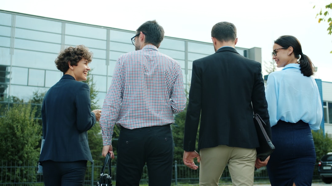 Four business people walking away from camera