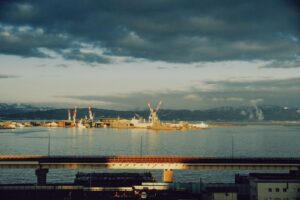 Industrial port with cranes on the water at dusk.