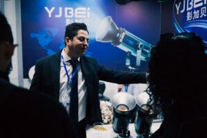Man in suit presenting equipment at a trade show.