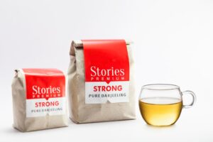 two bags of tea next to a cup of tea