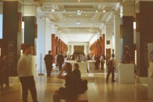 People walking through a grand museum hall.