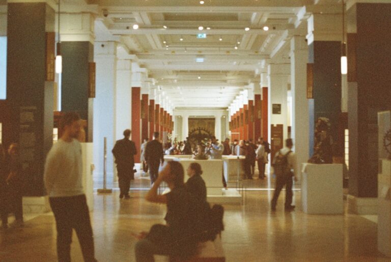 People walking through a grand museum hall.