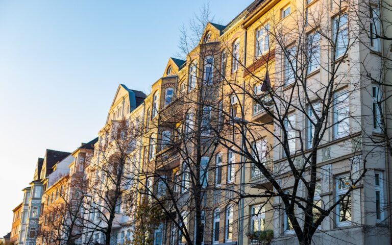 a row of multi - story buildings on a sunny day