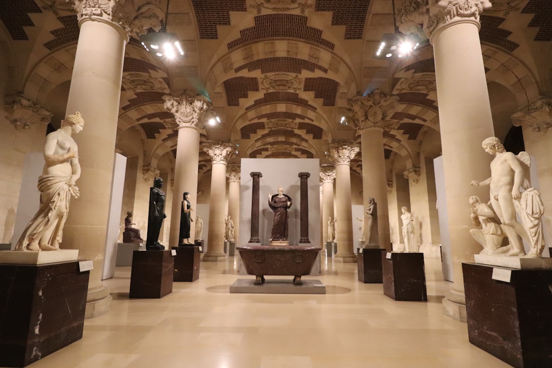 Classical sculptures displayed in a grand museum hall.