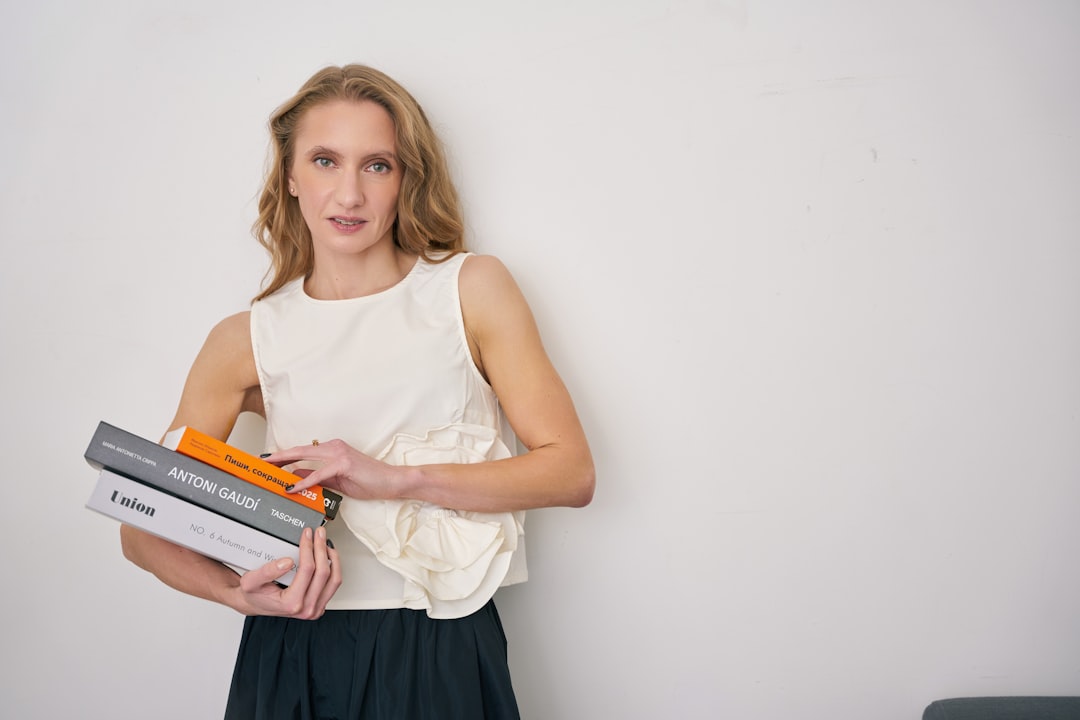a woman holding a stack of books in her hands