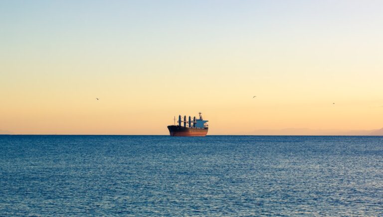 A large cargo ship sailing across a large body of water
