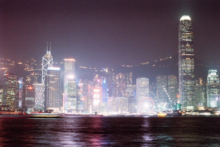 Vibrant cityscape with illuminated skyscrapers at night.