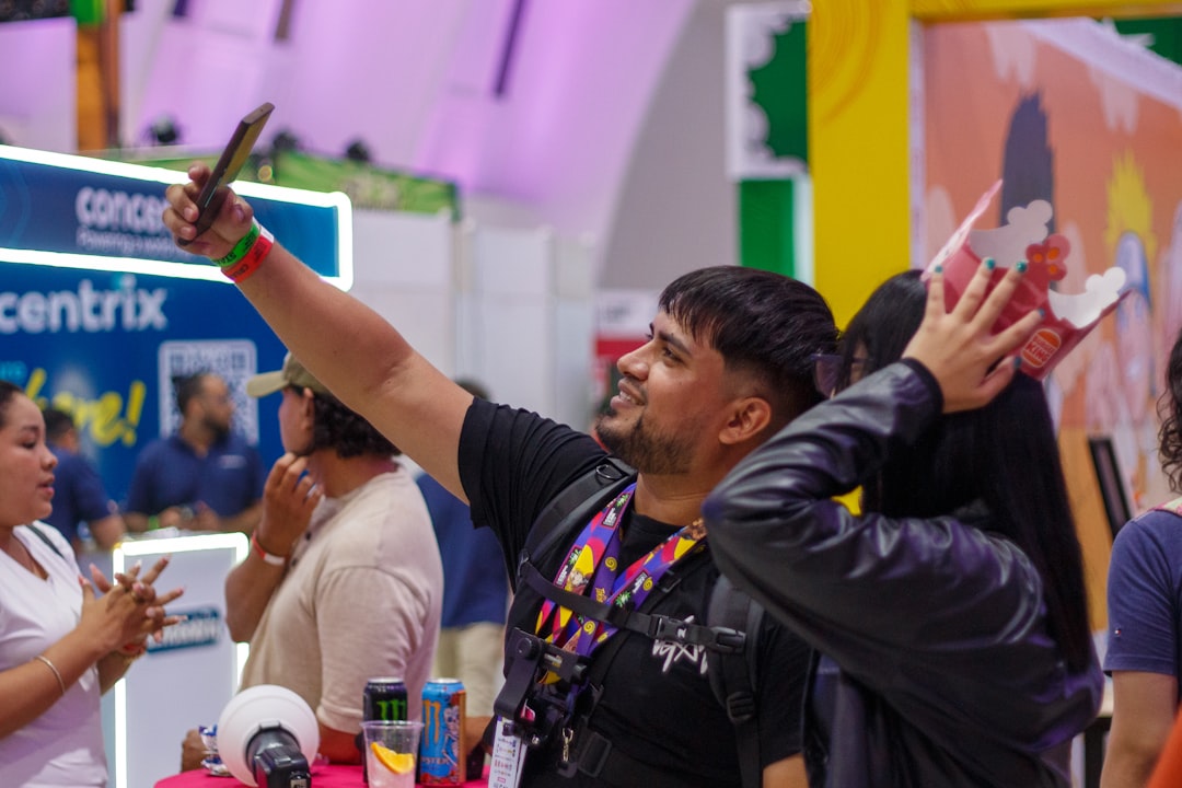 Man taking a selfie with a mask at an event.