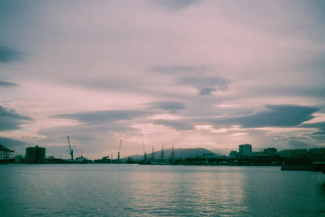 Harbor with boats and buildings under cloudy sky