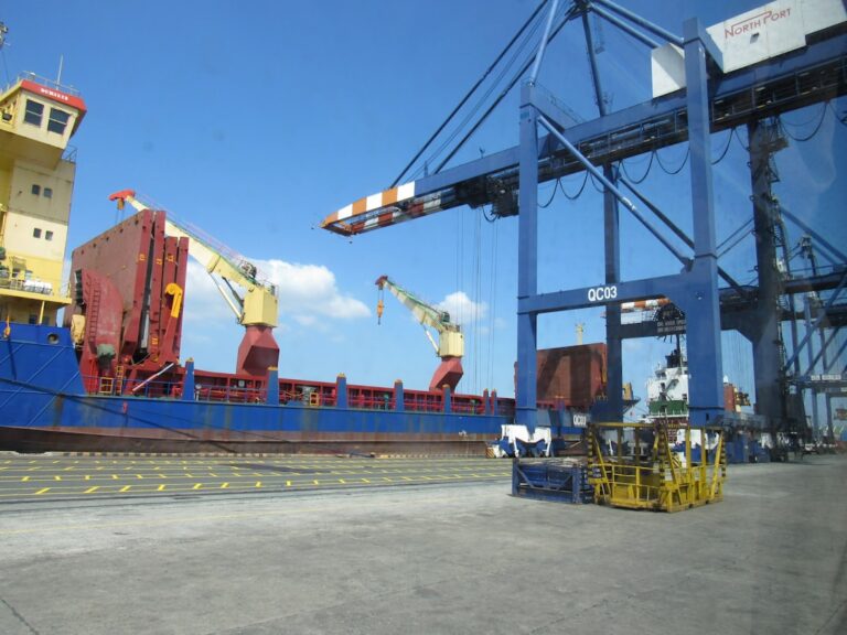 Cargo ship docked at port with large cranes