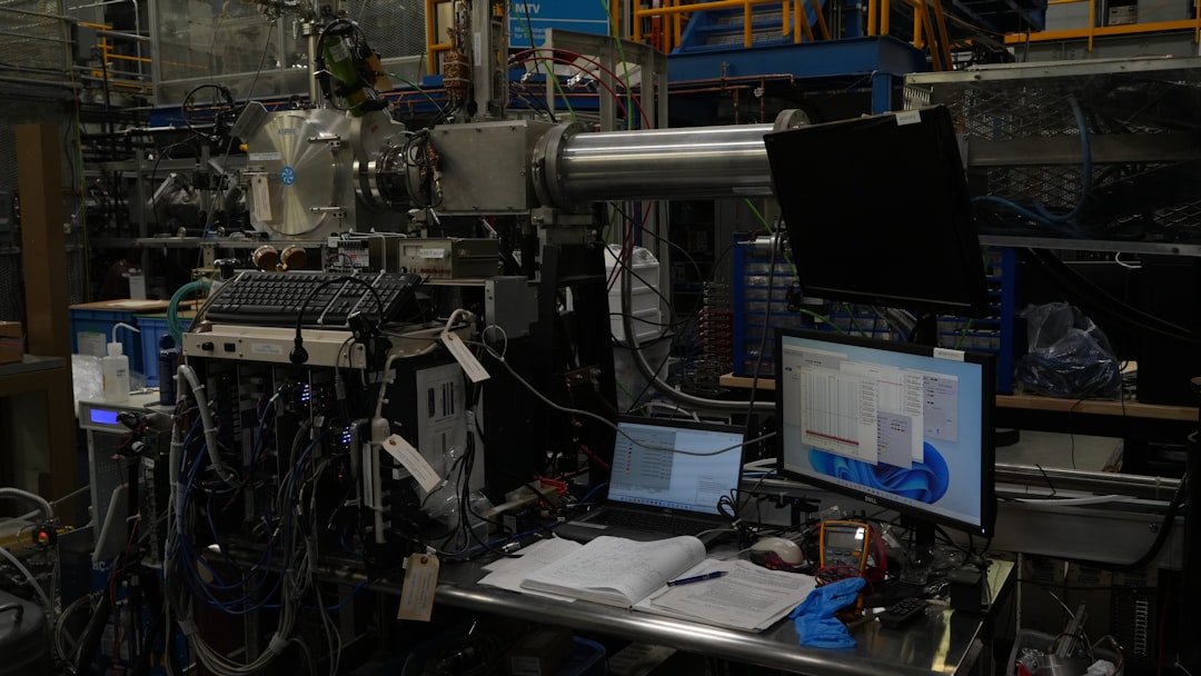 Complex scientific equipment and multiple computers in a laboratory setting.