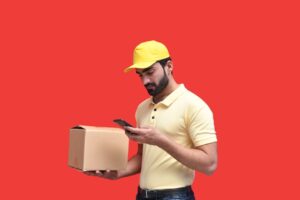 a man in a yellow hard hat looking at a phone