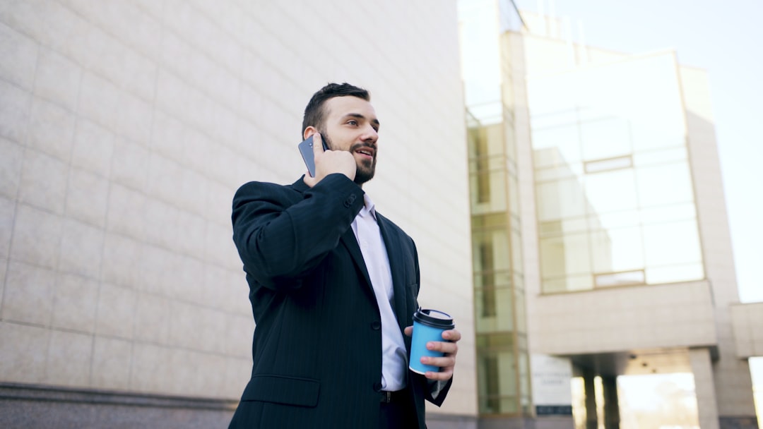 Man in suit talking on phone with coffee cup