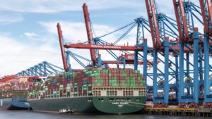 Container ship docked at a busy port with cranes