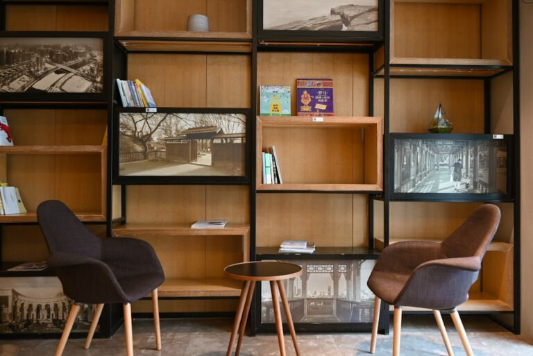 Two chairs and a table in front of a bookshelf.