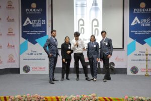 Young professionals pose on stage at a business conference.