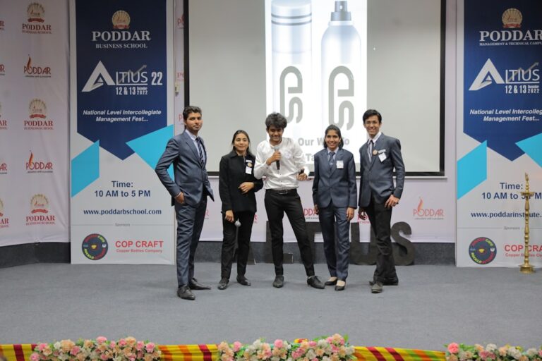 Young professionals pose on stage at a business conference.