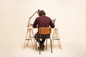 man in brown shirt sitting on brown wooden chair