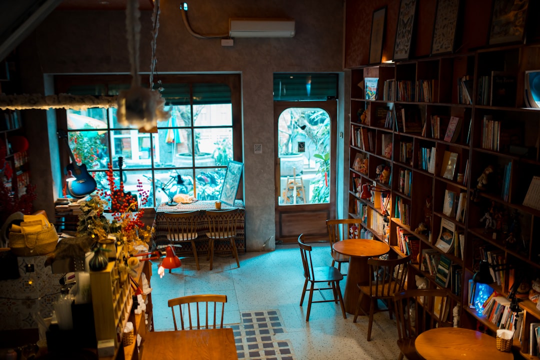Cozy cafe interior with bookshelves and seating areas.