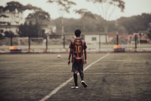 Young soccer player standing on field