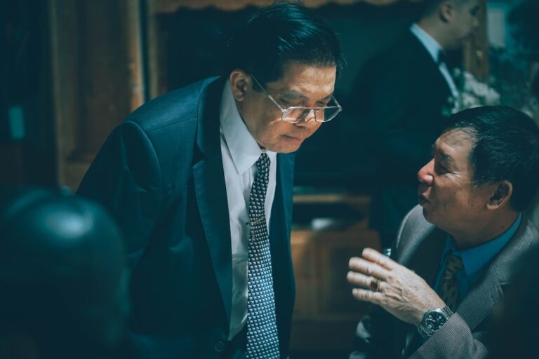 Two businessmen in suits talking intently