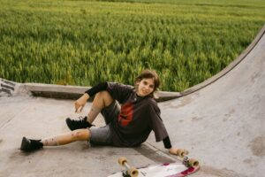 Young person resting on a skateboard ramp