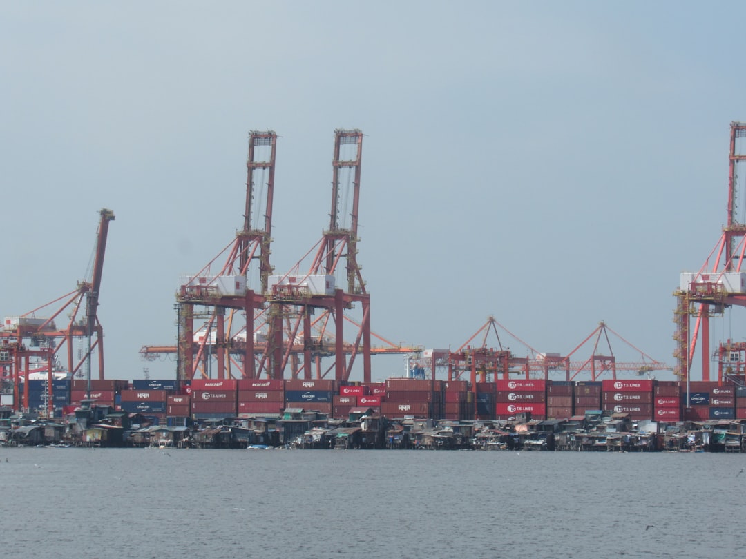 Large cranes and shipping containers at a busy port.