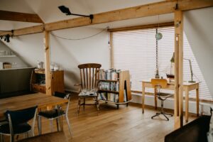 Cozy attic room with desk, chair, and books.