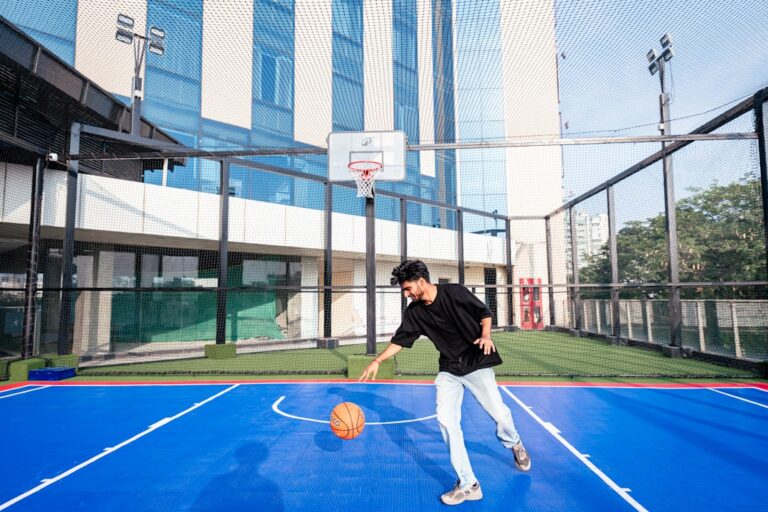 A man dribbling a basketball on a blue court.