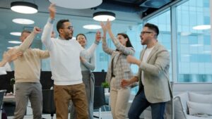 A diverse group of colleagues celebrating success in an office.