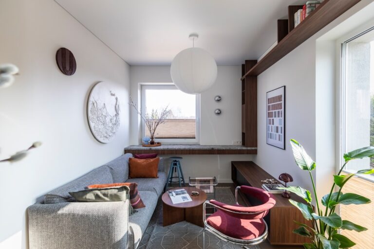 Cozy modern living space with sofa, armchair, and natural light.