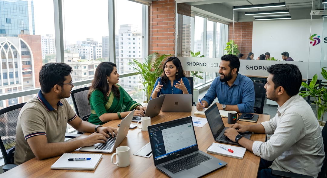 Five colleagues collaborating around a table in a modern office.