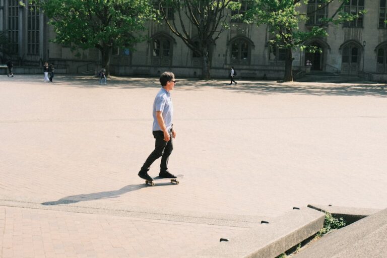 Young man skateboarding on a sunny, open plaza.