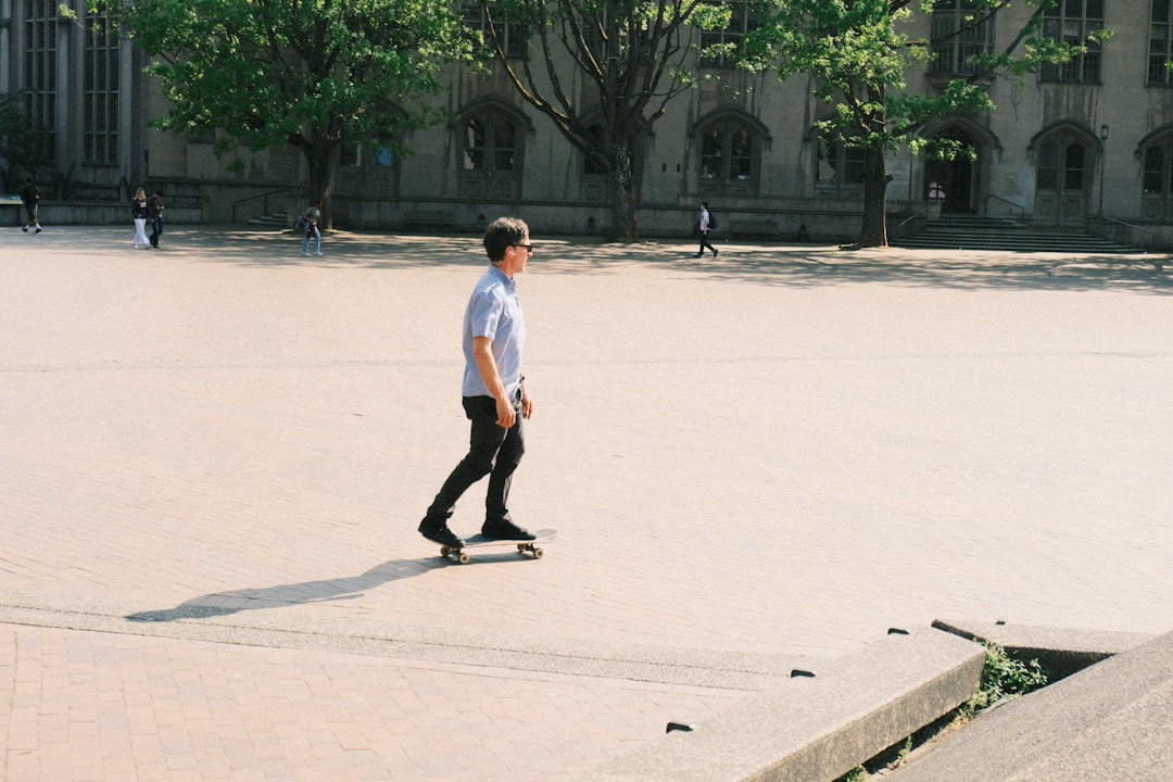 Young man skateboarding on a sunny, open plaza.