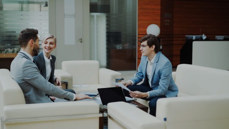 Three professionals in a modern office lounge.
