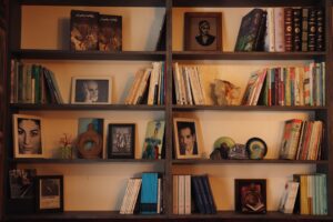 A bookshelf filled with lots of books next to a wall
