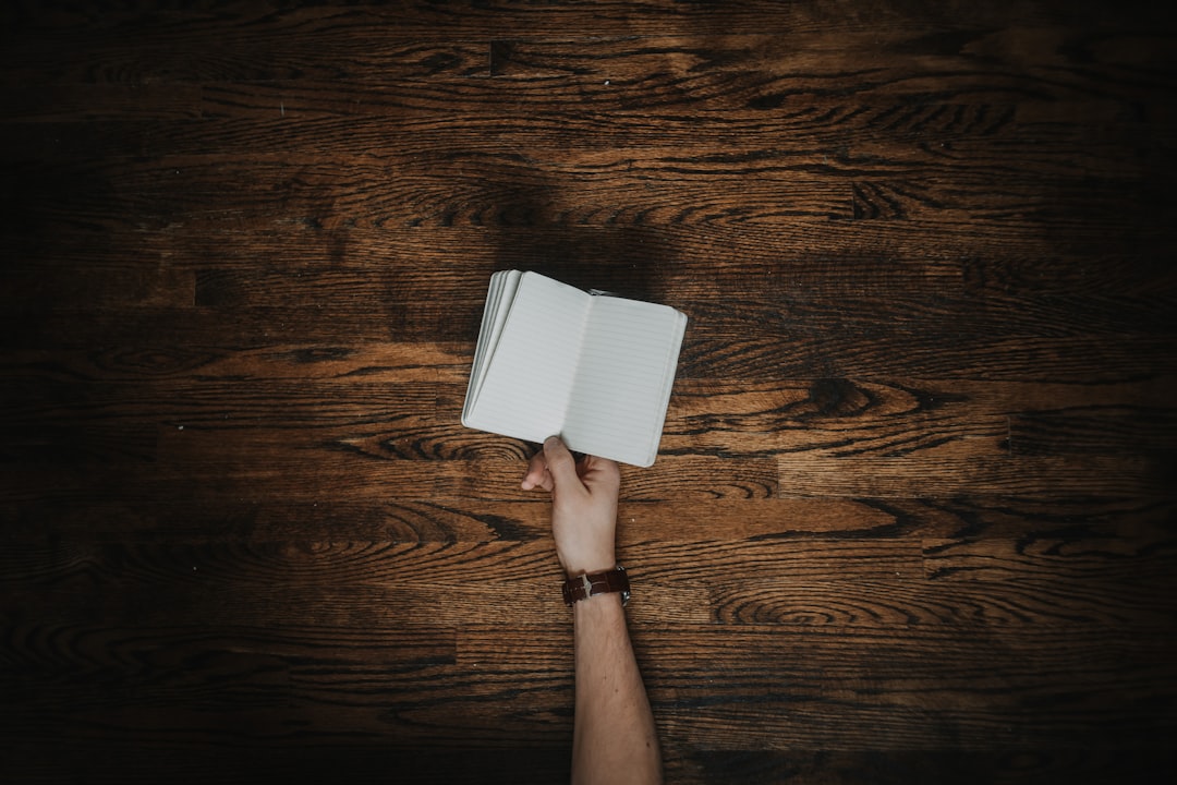 person holding empty open notebook