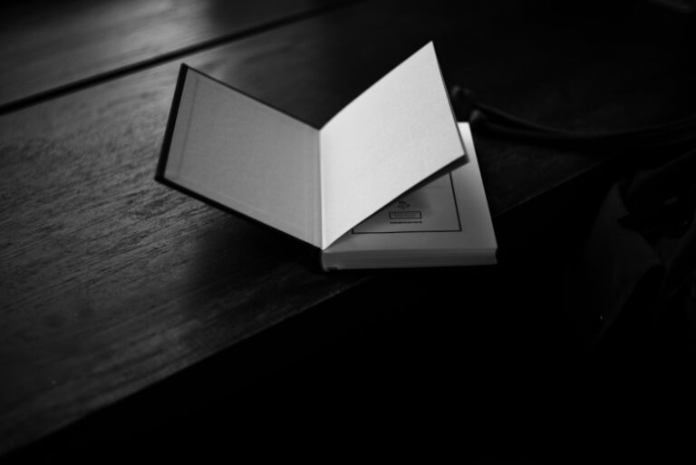 An open book rests on a dark wooden surface.