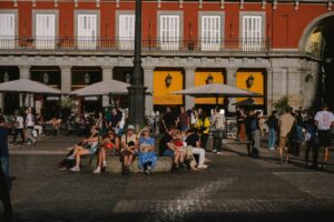 People relaxing in a plaza in front of a building.