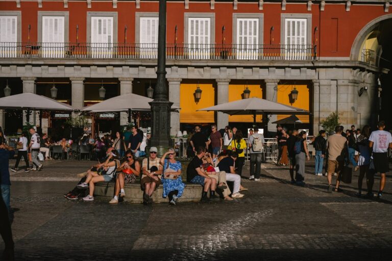 People relaxing in a plaza in front of a building.
