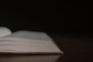an open book sitting on top of a wooden table