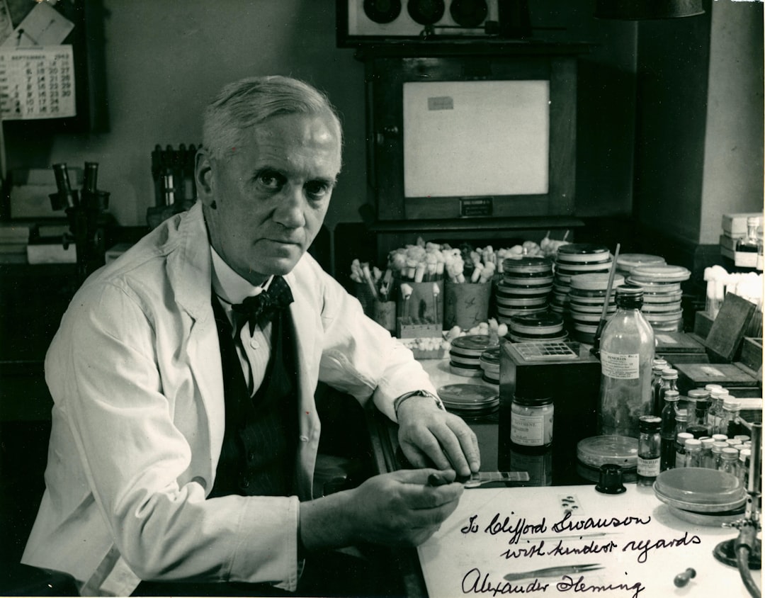 Scientist in lab coat with petri dishes and equipment.